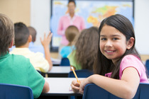 A student in a classroom looking behind her chair